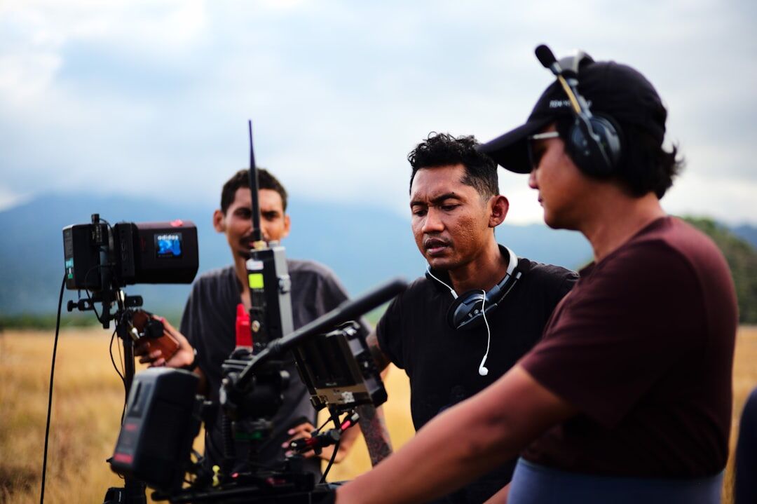 Journalist and technician reviewing footage on a professional camera in the field